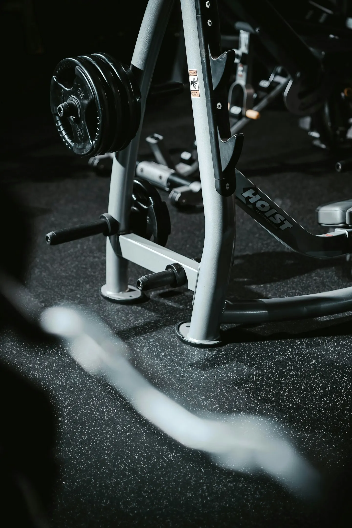 Close-up of a strength machine's steel frame on a rubber gym floor